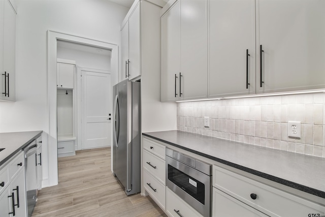 3312 Forest Ct, Tyler, TX 75703 - kitchen with stainless steel appliances, dark countertops, backsplash, and white cabinets