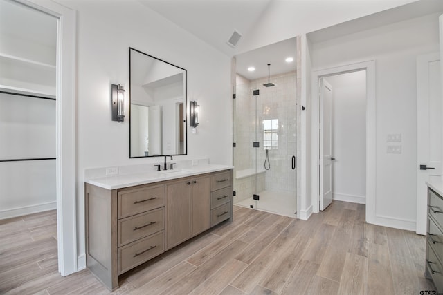 3312 Forest Ct, Tyler, TX 75703 - bathroom featuring vanity, a shower stall, lofted ceiling, wood finished floors, and baseboards