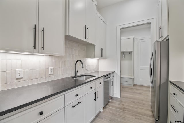 3312 Forest Ct, Tyler, TX 75703 - kitchen with appliances with stainless steel finishes, a sink, backsplash, white cabinetry, and dark countertops