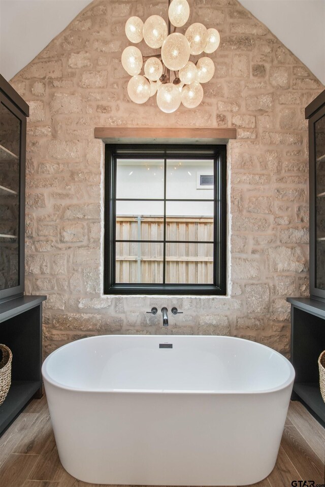 3312 Forest Ct, Tyler, TX 75703 - full bath featuring a soaking tub, wood finished floors, and vaulted ceiling