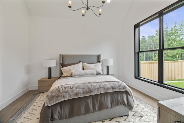 3312 Forest Ct, Tyler, TX 75703 - bedroom featuring a chandelier, wood finished floors, baseboards, and vaulted ceiling