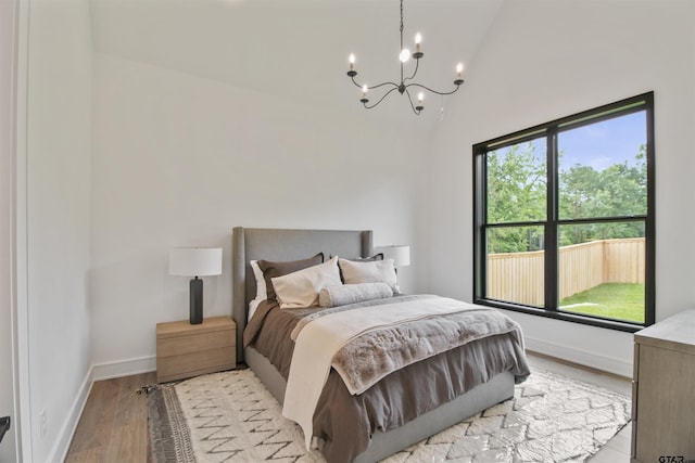 3312 Forest Ct, Tyler, TX 75703 - bedroom with a chandelier, light wood-style floors, vaulted ceiling, and baseboards