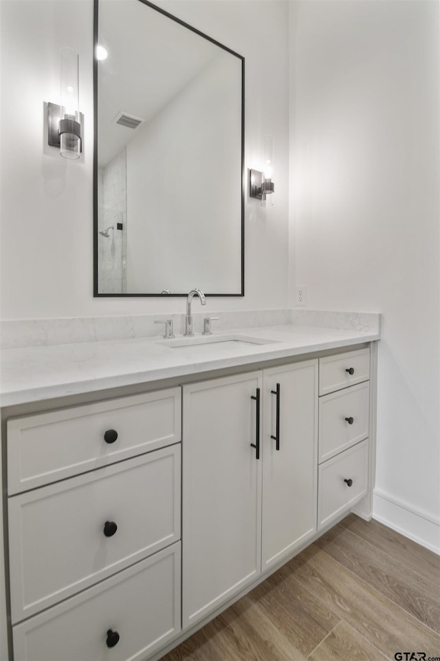 3312 Forest Ct, Tyler, TX 75703 - bathroom featuring vanity, wood finished floors, baseboards, and a shower