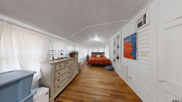 bedroom with wooden walls, vaulted ceiling, wooden ceiling, and wood-type flooring