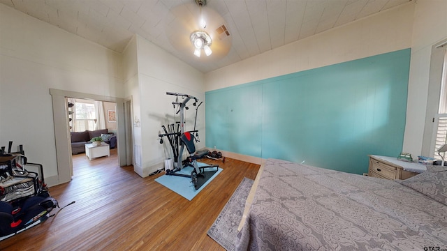 bedroom with light wood-type flooring and lofted ceiling