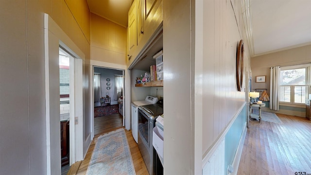 interior space featuring light wood-type flooring, crown molding, and independent washer and dryer