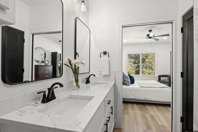 bathroom with hardwood / wood-style flooring, ceiling fan, and vanity