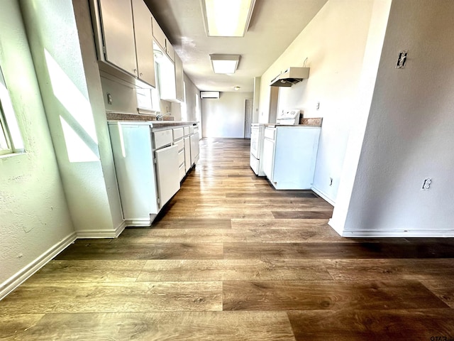 kitchen with white cabinets, light hardwood / wood-style floors, and white stove