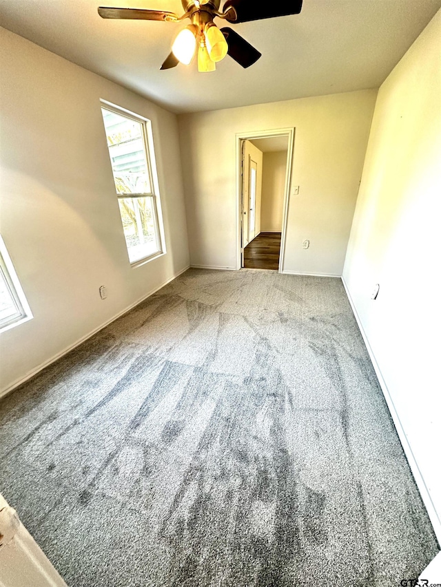 empty room with ceiling fan and carpet