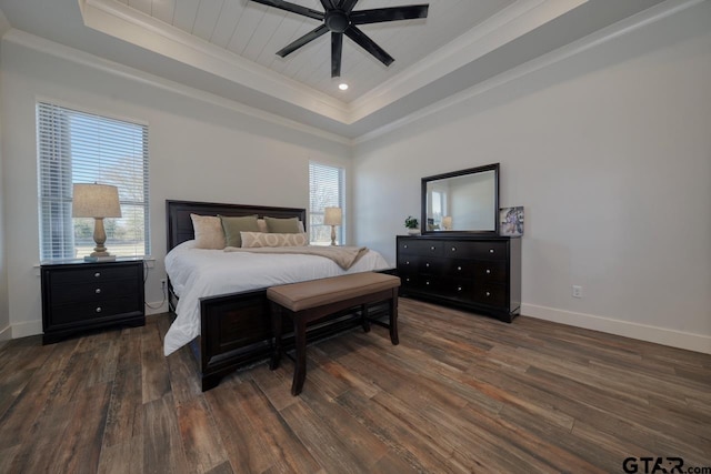 bedroom featuring ceiling fan, dark hardwood / wood-style flooring, crown molding, and a tray ceiling