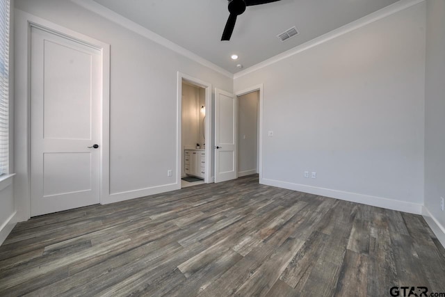 unfurnished bedroom featuring ensuite bath, ceiling fan, ornamental molding, and dark wood-type flooring