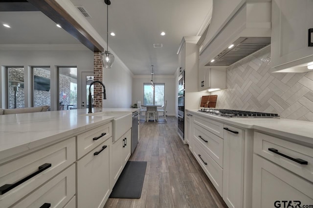 kitchen featuring premium range hood, pendant lighting, stainless steel appliances, decorative backsplash, and crown molding