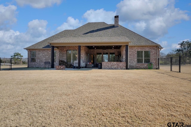 rear view of house featuring a yard