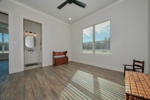 unfurnished bedroom featuring ensuite bathroom, multiple windows, hardwood / wood-style flooring, and crown molding