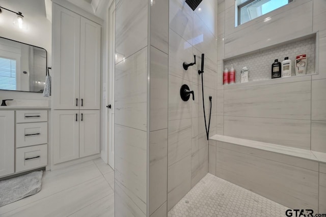 bathroom with a tile shower and plenty of natural light