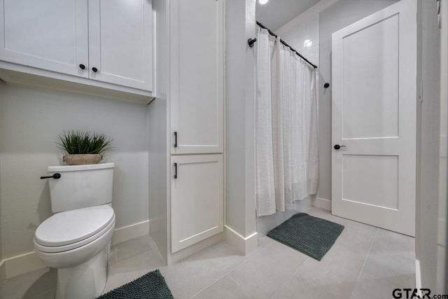 bathroom with toilet, tile patterned flooring, and walk in shower