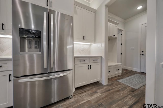 kitchen featuring stainless steel fridge with ice dispenser, white cabinetry, backsplash, and crown molding