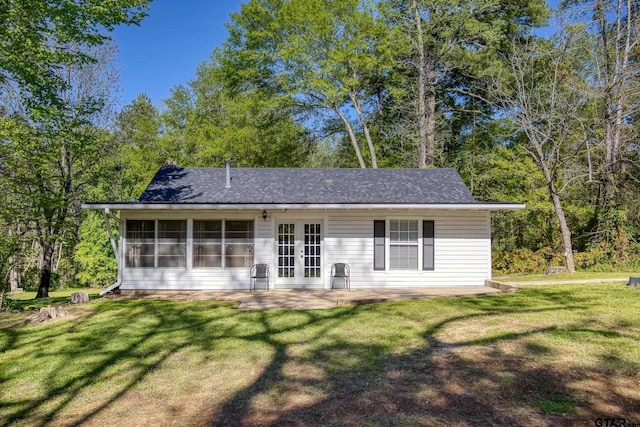 rear view of property with a sunroom and a yard