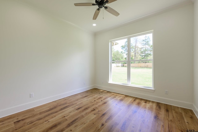 unfurnished room featuring crown molding, a wealth of natural light, hardwood / wood-style flooring, and ceiling fan