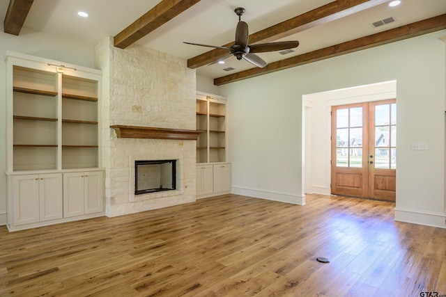 unfurnished living room featuring french doors, light wood-type flooring, ceiling fan, and beam ceiling