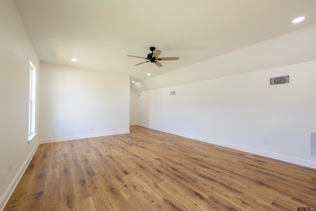 empty room featuring hardwood / wood-style flooring, ceiling fan, and vaulted ceiling