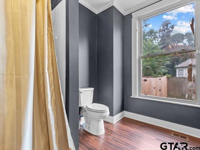 bathroom featuring ornamental molding, hardwood / wood-style flooring, and toilet