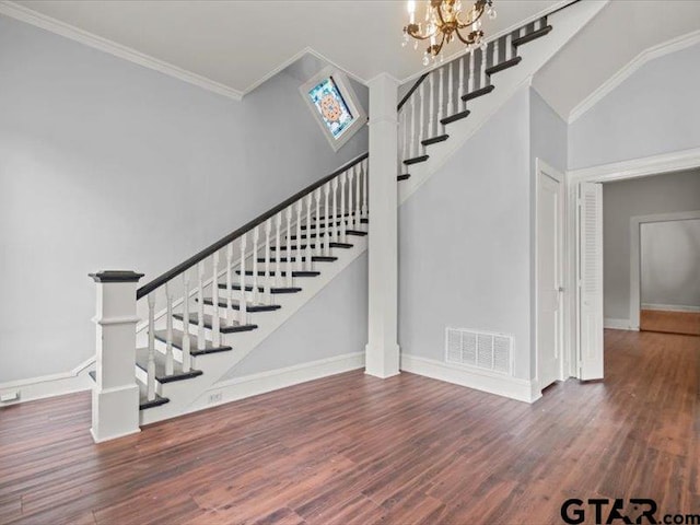 staircase with high vaulted ceiling, wood-type flooring, a chandelier, and crown molding