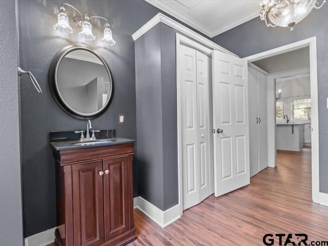 bathroom with vanity, hardwood / wood-style floors, and crown molding