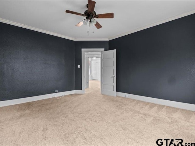 carpeted spare room with ceiling fan and ornamental molding