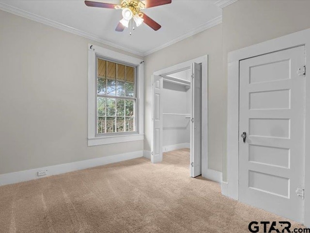 unfurnished bedroom featuring light carpet, ceiling fan, crown molding, and a closet