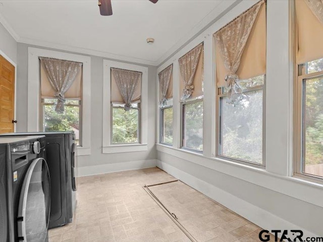 sunroom / solarium featuring washing machine and dryer, ceiling fan, and plenty of natural light