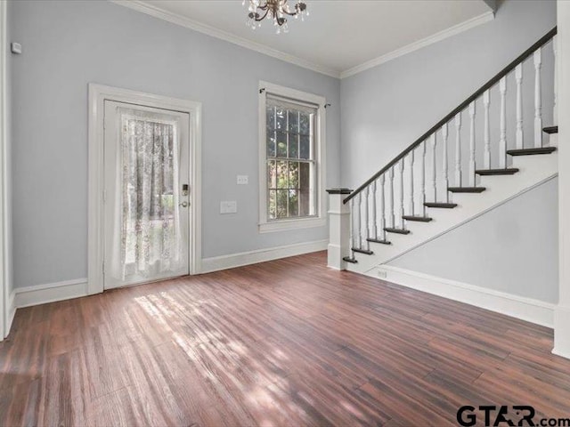 entryway with ornamental molding, dark hardwood / wood-style floors, and an inviting chandelier