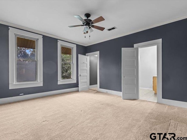 unfurnished bedroom featuring ornamental molding, light colored carpet, and ceiling fan