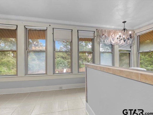 unfurnished sunroom featuring a healthy amount of sunlight and an inviting chandelier