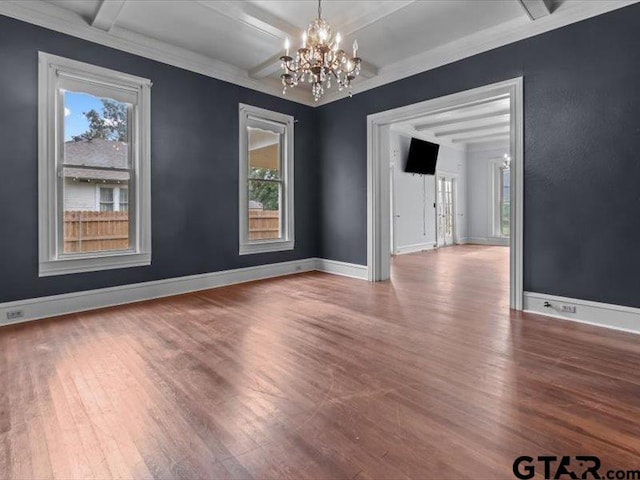 unfurnished room featuring hardwood / wood-style floors, a wealth of natural light, a chandelier, and beam ceiling