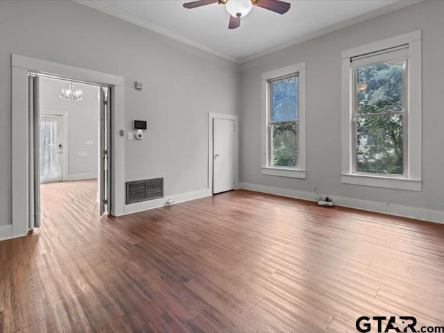 empty room with hardwood / wood-style floors, ceiling fan with notable chandelier, and ornamental molding