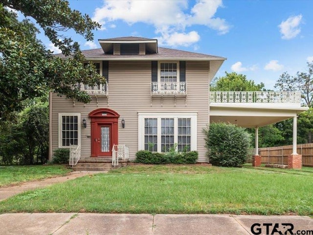 view of front of house featuring a front yard and a balcony