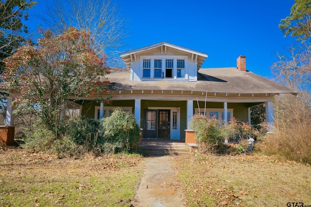 view of front of property with a porch and a chimney