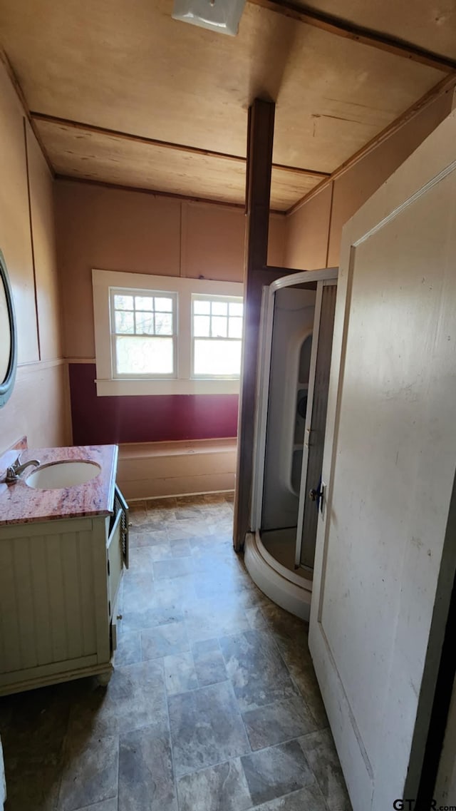 bathroom featuring a stall shower, stone finish floor, and vanity