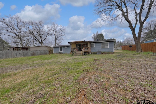 rear view of property with a yard and fence