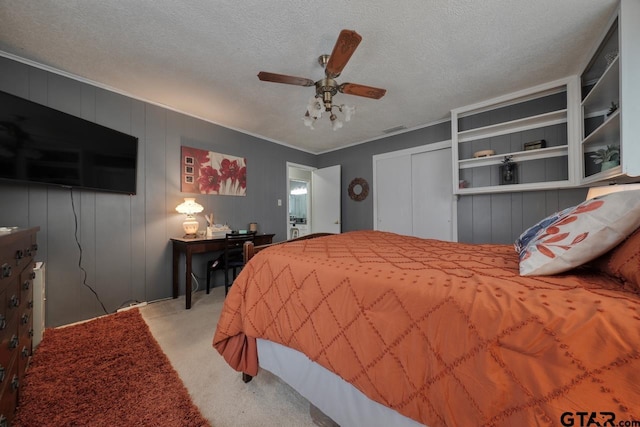 carpeted bedroom with ornamental molding, a closet, visible vents, and a textured ceiling