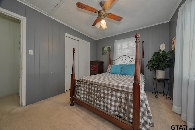 bedroom with carpet floors, a ceiling fan, ornamental molding, and a closet