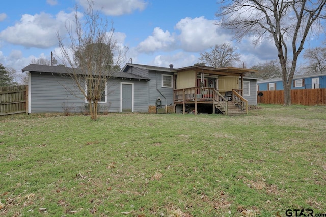 back of house with a yard, a fenced backyard, and a wooden deck