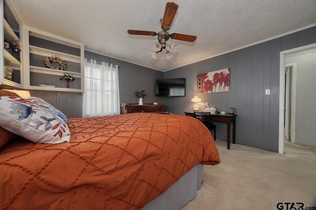 bedroom featuring ceiling fan, ornamental molding, a textured ceiling, and light colored carpet