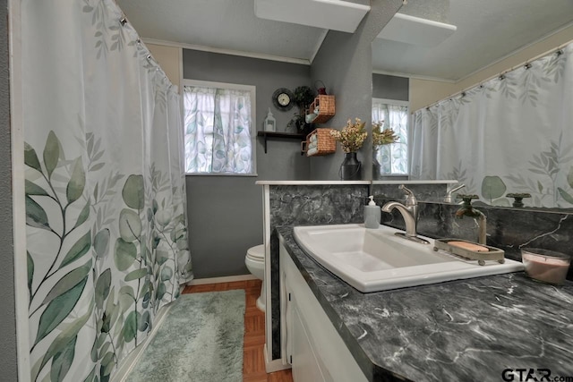 bathroom with toilet, ornamental molding, a shower with shower curtain, and vanity