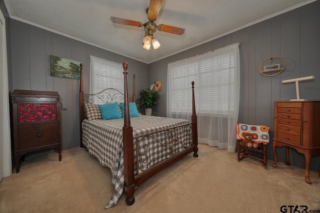 carpeted bedroom with ornamental molding and a ceiling fan