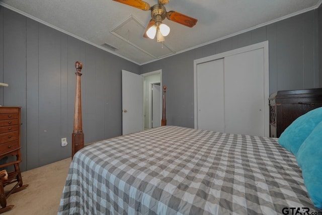 bedroom with visible vents, ornamental molding, carpet flooring, and attic access