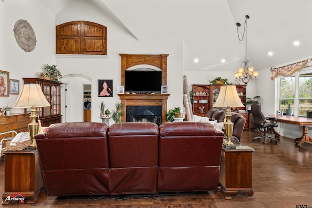 living room featuring high vaulted ceiling, a premium fireplace, dark hardwood / wood-style flooring, and a notable chandelier