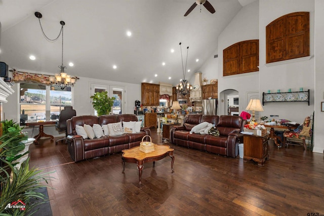 living room with ceiling fan with notable chandelier, high vaulted ceiling, and dark hardwood / wood-style floors