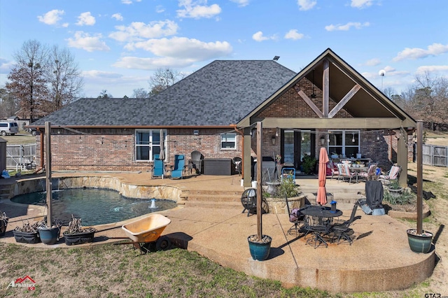 rear view of property featuring a patio area and a fenced in pool